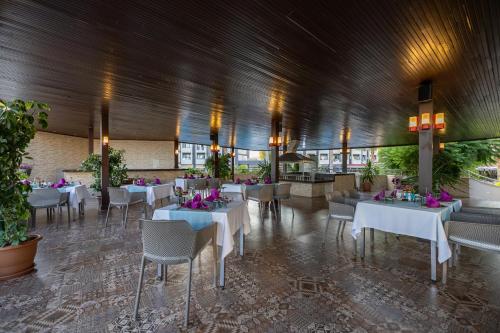a restaurant with white tables and chairs and plants at VONRESORT Elite & Aqua - Ultra All Inclusive & Kids Concept in Side