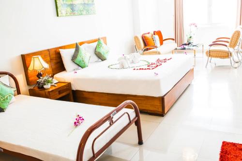 a hotel room with two beds and chairs at Kiên Cường 2 Hotel in Da Nang