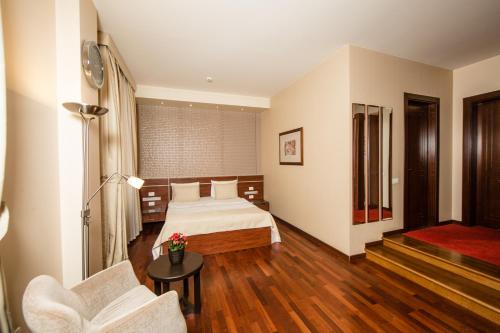 a bedroom with a bed and a couch and a chair at Passage Hotel in Baku