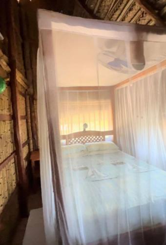 a bedroom with a bed with a window in it at CASAPANSY Barra Beach Mozambique in Miramar