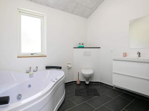 a white bathroom with a tub and a toilet at 8 person holiday home in Læsø-By Traum in Læsø