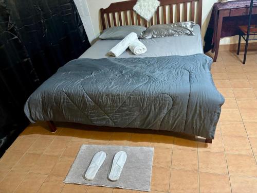 a bed with slippers on the floor in a bedroom at Ally home 12 23 in Thung Si Kan