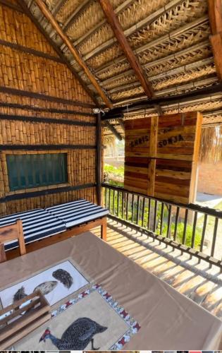a room with a table and a bed in a straw hut at CASAPANSY Barra Beach Mozambique in Miramar