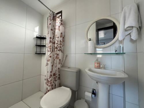 une salle de bain avec toilettes, lavabo et miroir dans l'établissement Casa Privê Maragogi 26 - Pé na areia, à Maragogi