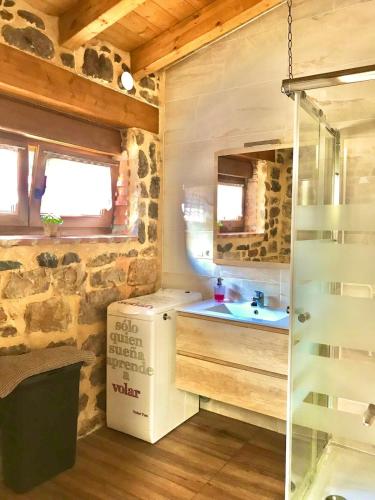 a bathroom with a sink and a shower in a cabin at La casa del Río in Pujayo
