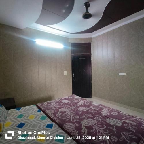 a bedroom with a bed with a purple blanket at Ghanshyam Lodge Unit 2 in Ghaziabad