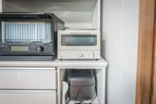 a microwave and a toaster oven on a kitchen counter at HANABI棟-BASE棟 サウナ BBQ 農業体験 花火 が楽しめる ペット可 貸し切りで最大12名宿泊可能 Wi-Fi完備 in Katori