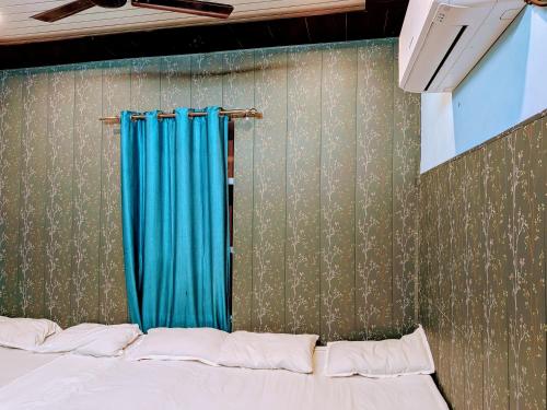 a bedroom with a bed with a blue curtain at Maa Tara AC Home Stay in Varanasi