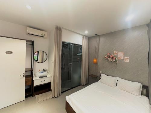 a bedroom with a white bed and a sink at Lacasa Homestay in Hue