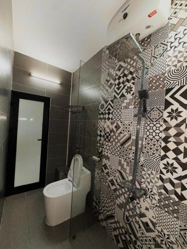 a bathroom with a shower and a toilet and a wall at Lacasa Homestay in Hue