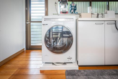 a washing machine is sitting in a kitchen at HANABI棟-BASE棟 サウナ BBQ 農業体験 花火 が楽しめる ペット可 貸し切りで最大12名宿泊可能 Wi-Fi完備 in Katori