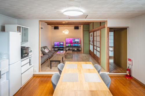 a living room with a table and a couch at HANABI棟-BASE棟 サウナ BBQ 農業体験 花火 が楽しめる ペット可 貸し切りで最大12名宿泊可能 Wi-Fi完備 in Katori