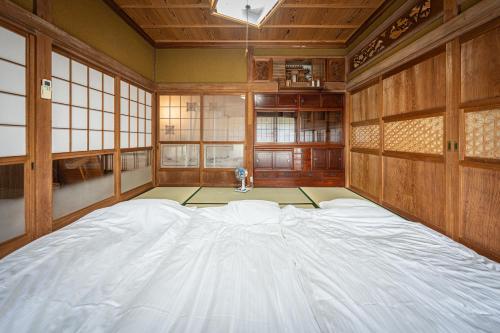 a room with a large bed in a room with windows at HANABI棟-BASE棟 サウナ BBQ 農業体験 花火 が楽しめる ペット可 貸し切りで最大12名宿泊可能 Wi-Fi完備 in Katori