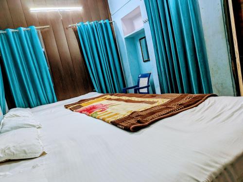 a bedroom with a bed with blue curtains at Maa Tara AC Home Stay in Varanasi