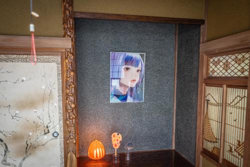 a picture of a girl on a wall next to a table at HANABI棟-BASE棟 サウナ BBQ 農業体験 花火 が楽しめる ペット可 貸し切りで最大12名宿泊可能 Wi-Fi完備 in Katori