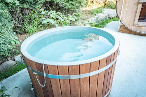 a large wooden tub filled with a pool of water at HANABI棟-BASE棟 サウナ BBQ 農業体験 花火 が楽しめる ペット可 貸し切りで最大12名宿泊可能 Wi-Fi完備 in Katori