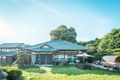 a large house with a yard with a patio at HANABI棟-BASE棟 サウナ BBQ 農業体験 花火 が楽しめる ペット可 貸し切りで最大12名宿泊可能 Wi-Fi完備 in Katori
