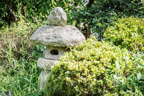 a stone bird house in the middle of some bushes at HANABI棟-BASE棟 サウナ BBQ 農業体験 花火 が楽しめる ペット可 貸し切りで最大12名宿泊可能 Wi-Fi完備 in Katori
