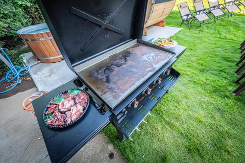 a barbecue grill with a pan of meat on it at HANABI棟-BASE棟 サウナ BBQ 農業体験 花火 が楽しめる ペット可 貸し切りで最大12名宿泊可能 Wi-Fi完備 in Katori