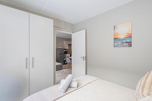 ランゲバーンにあるArch House Langebaan - Modern Stay Near Beach & Club Mykonosのベッドと鏡のある白い寝室
