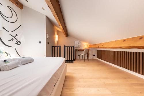 a bedroom with a white bed and a wooden floor at Duplex 4 pers climatisation et charme méditerranéen in Vallauris