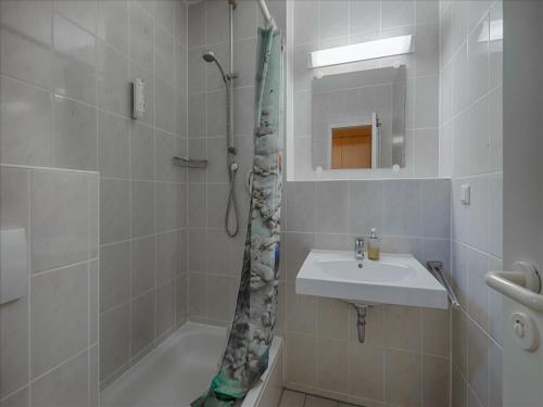 a white bathroom with a sink and a shower at Feriendorf Rugana - Klassik 1-Raum Appartement mit Terrasse A51 in Dranske
