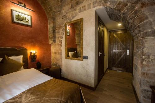 a bedroom with a bed and a stone wall at Passage Hotel in Baku