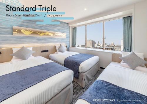a hotel room with three beds and a window at HOTEL MYSTAYS Kanazawa Katamachi in Kanazawa