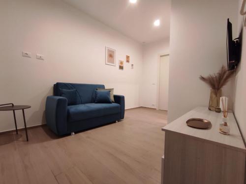 a living room with a blue couch and a table at Appartamento Dante 2 in Alcamo