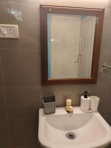 a bathroom with a sink and a mirror at Unpack Hostel in Puducherry