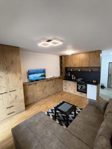 ein großes Wohnzimmer mit Couch und Küche in der Unterkunft EastWest Nest Sarajevo in Vogošća