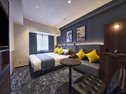 a hotel room with a bed and a couch at Hotel Villa Fontaine Kobe Sannomiya in Kobe