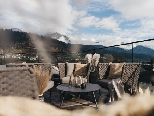 a balcony with couches and a table with a view at JOHANN Schladming in Schladming