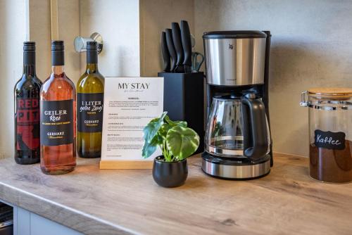 a kitchen counter with bottles of wine and a blender at MY STAY - Erholung am Chiemsee in zentraler Lage in Prien in Prien am Chiemsee