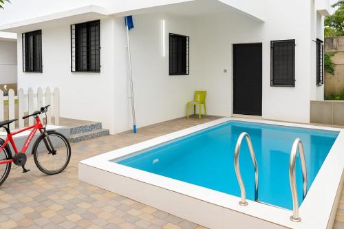 a red bike parked next to a house with a swimming pool at ll EMPYREAN STAY ll MOCKTAIL VILLA ll 2BHK ll AC ll PVT POOL ll FREE WIFI ll in Lonavala