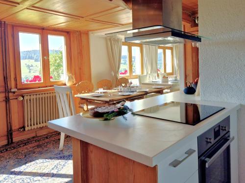 a kitchen with a counter and a table with chairs at Echtes Schwarzwaldhaus - Traditionell & Modern in Bernau im Schwarzwald