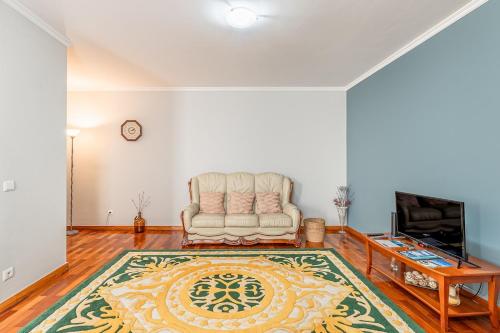 a living room with a chair and a television at Lobos Village in Câmara de Lobos