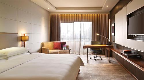 a hotel room with a bed and a desk and a television at Crowne Plaza Kunming City Centre by IHG in Kunming