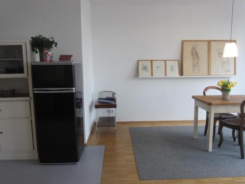 a kitchen with a black refrigerator and a table at K9 Wohnungen in Münster