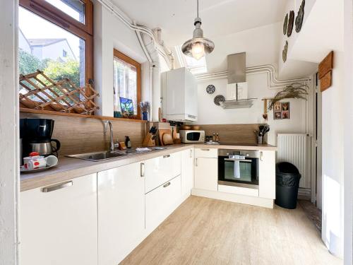 a kitchen with white cabinets and a sink at Logement entier hyper centre Chartres in Chartres