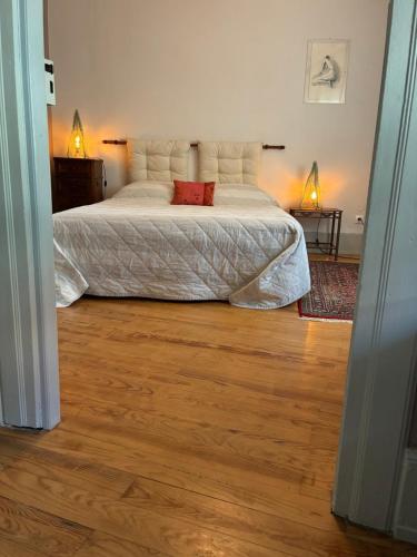 a bedroom with a large bed and a wooden floor at Le Grenier - Piscine et SPA in Marlenheim