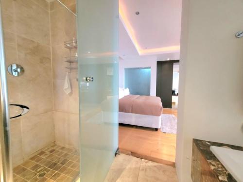 a bathroom with a shower and a bed in a room at LuxeBnB in Johannesburg