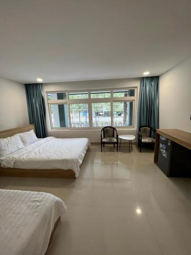 a bedroom with two beds and a window at Hoàng Lâm Hotel in Thu Dau Mot