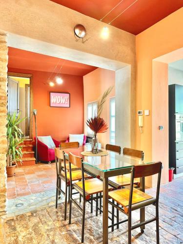 a dining room with orange walls and a table and chairs at baroLOFT in Barolo