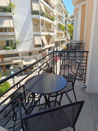 a patio with tables and chairs on a balcony at Exis Hotel in Athens