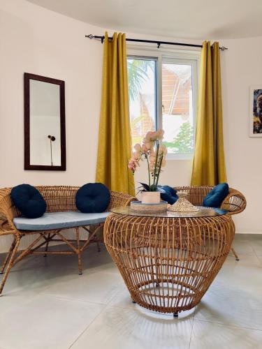 a living room with wicker chairs and a table at Olzadia Boutique Hotel in Michamvi