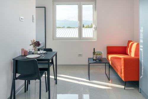 a living room with a table and a couch at TQ City Apartments in Radanovići