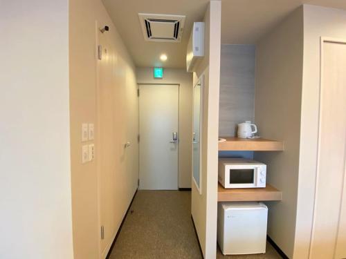 a small room with a microwave and a hallway at winco - Vacation STAY 06658v in Tokyo