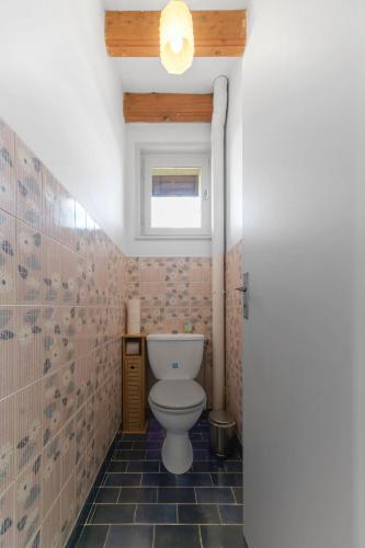 a bathroom with a toilet and a window at Le Berylune - Maison 2 chambres - Campagne in Abrest