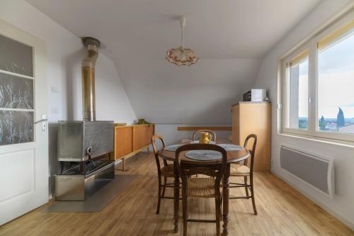 a kitchen with a table and chairs and a stove at Le Berylune - Maison 2 chambres - Campagne in Abrest